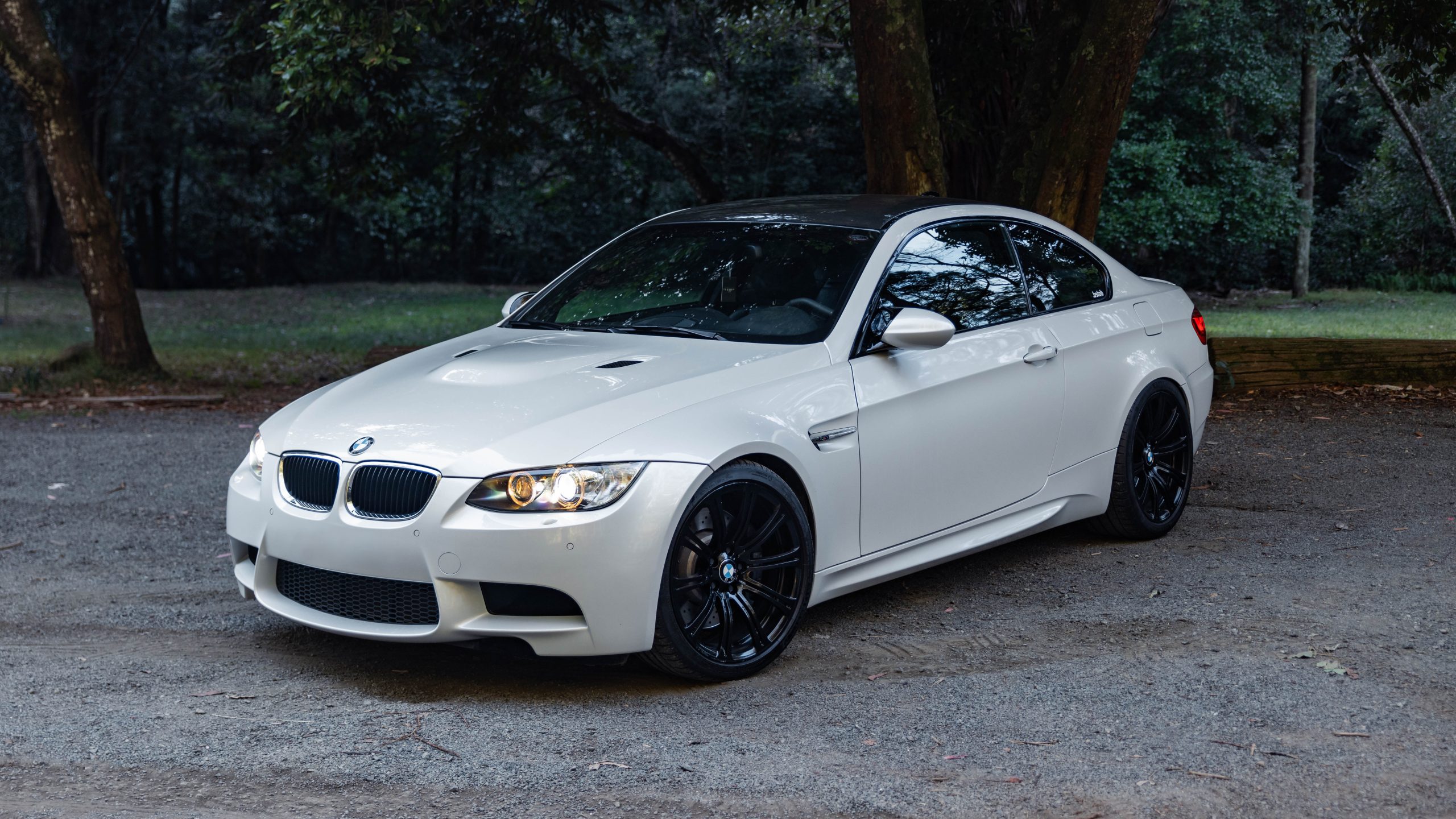 White 2008 BMW M3 facing left slightly front on view