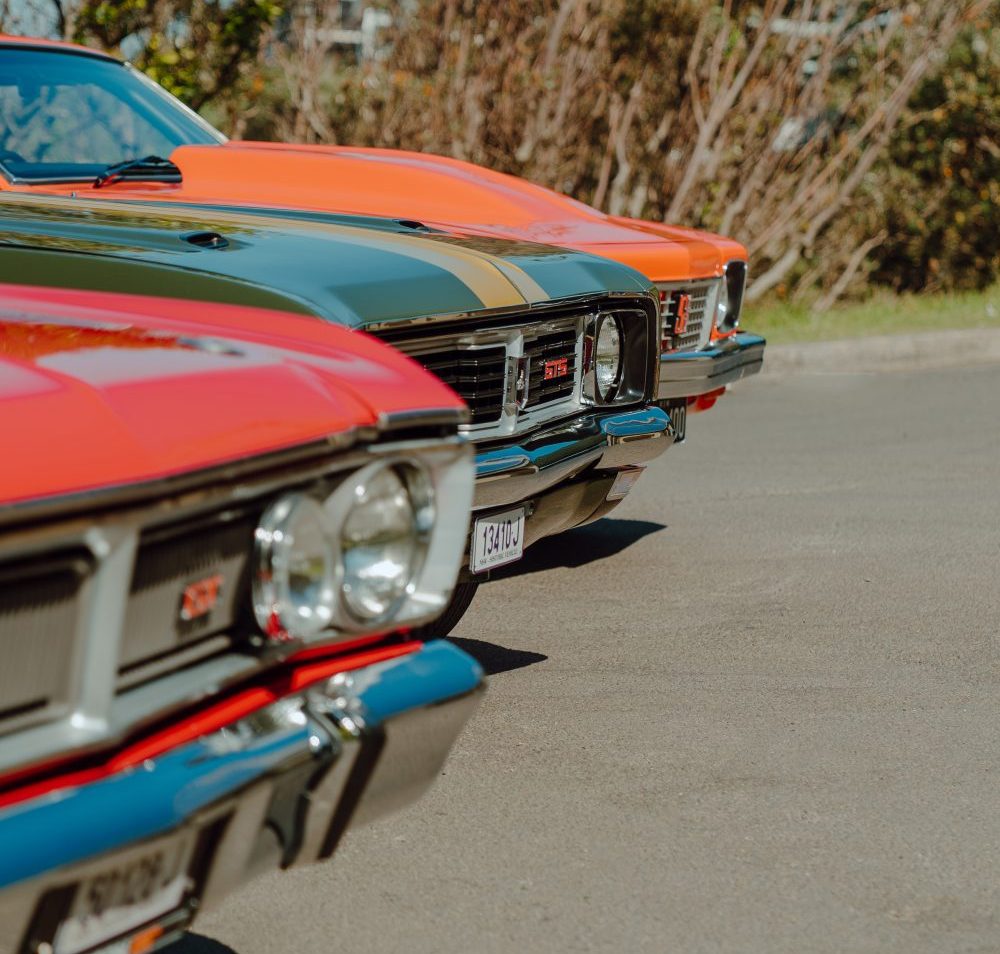 From front: red 1970 Ford Falcon XY GT, green 1969 Holden Monaro GTS Coupe, orange 1976 Holden Torana
